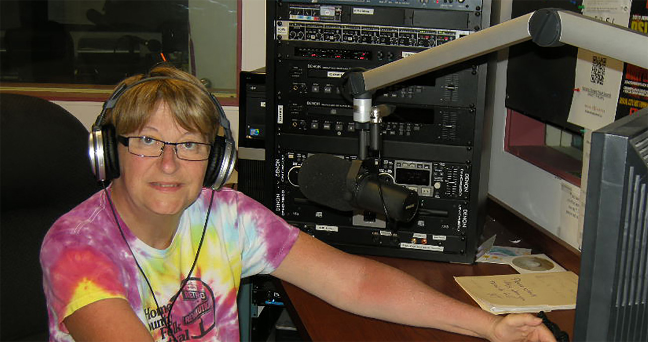 A woman in a tie dye shirt is sitting in front of a computer. | Susan ...